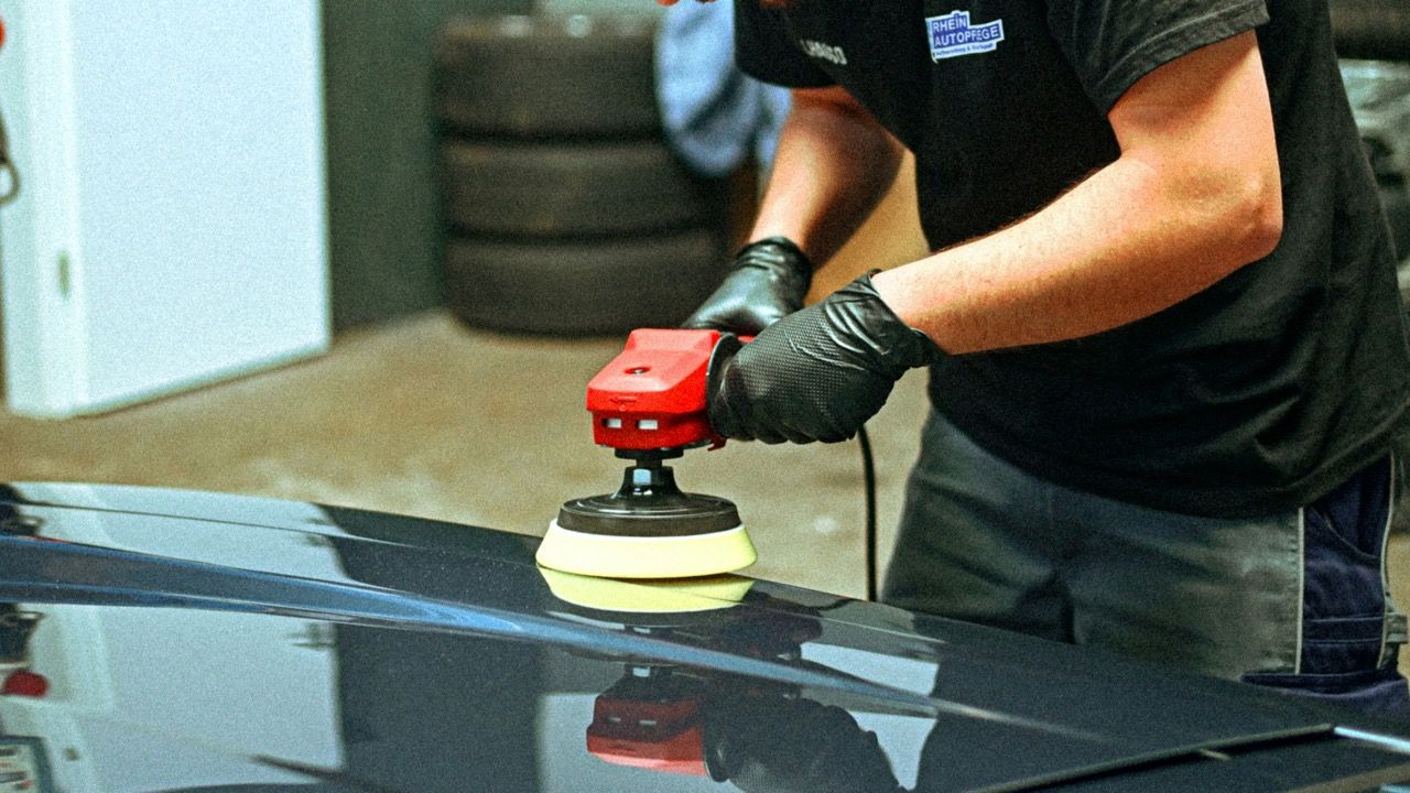 Lackpolitur einer dunklen Motorhaube mit der Poliermaschine